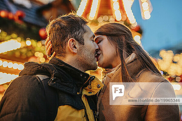 Loving couple kissing at Christmas market
