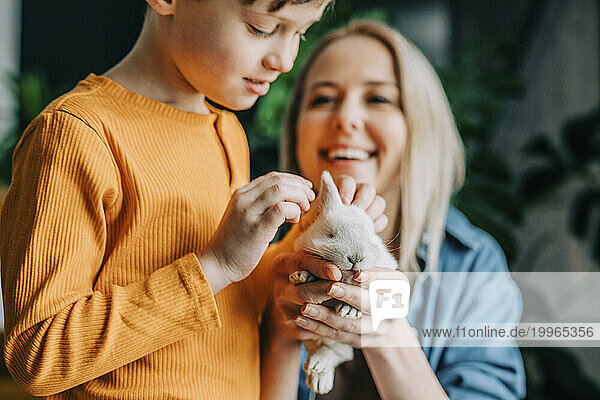 Mother and son playing with bunny at home