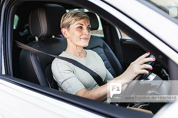Mature woman wearing seat belt and driving car