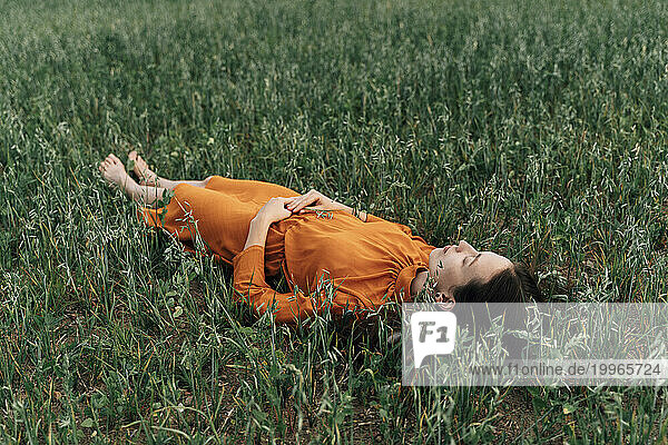 Woman relaxing in crops in corn field