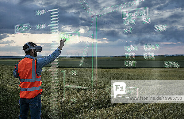 Engineer programming digital wind turbine model through VR glasses in field