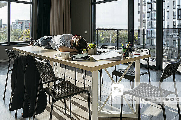 Businesswoman lying on table and relaxing in office