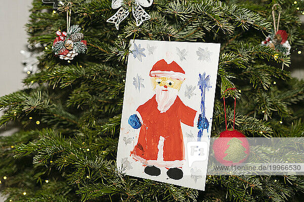 Santa Claus painting hanging on Christmas tree