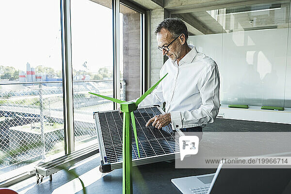 Businessman examining solar panel on desk
