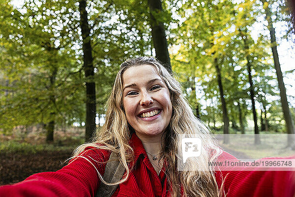 Happy blond woman taking selfie in Cannock chase forest