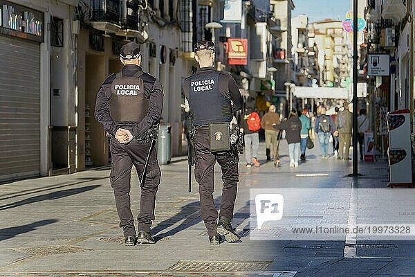 01  22  2024 ronda  malaga  spanien Zwei nicht erkennbare Polizisten  die mit dem Rücken zugewandt in einer Einkaufsstraße patrouillieren