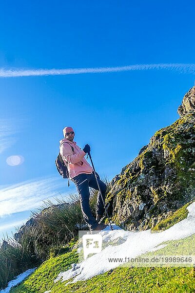 Porträt eines Mannes auf dem Gipfel eines Berges beim Trekking  der mit einem Stock geht