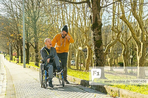 Betreuer  der mit einem behinderten Mann in einem Stadtpark spricht