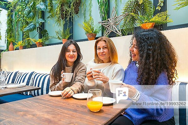 Drei verschiedene erwachsene kaukasische Frauen  die in einer Cafeteria chillen und reden