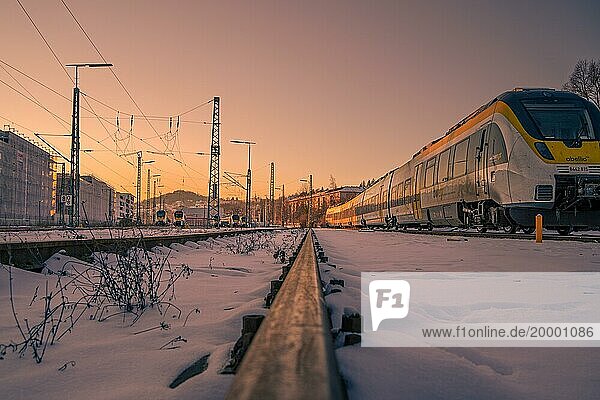 Zug auf schneebedeckten Gleisen bei Sonnenuntergang mit Fokus auf Vordergrund  Pforzheim  Deutschland  Europa