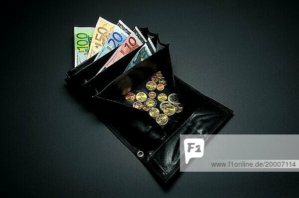 Nahaufnahme einer schwarzen Kellnerbörse oder Brieftasche  Kleingeld oder lose Münzen in Euro und Cent  ein 5  10  20  50 und 100 Euro Schein ist sichtbar