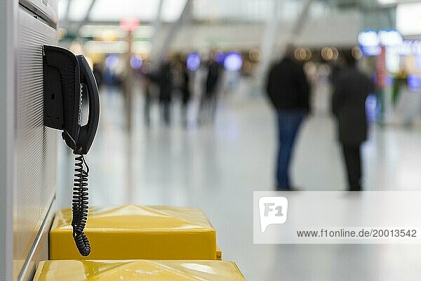 Altertümliches Wandtelefon in der Abflughalle eines Flughafens
