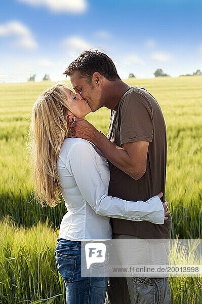 Paar küsst sich am Rande eines Getreidefeldes