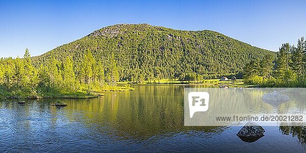 Ein kleiner See in Nähe von Vinje  Querformat  Binnengewässer  Ufer  Berg  Landschaftsaufnahme  Panoramaaufnahme  Wolkenloser blauer Himmel  Sommer  Abendlicht  Vestfold og Telemark  Edland  Norwegen  Europa