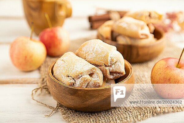 Hausgemachte süße Kekse mit Apfelmarmelade und Tasse Kaffee auf weißem hölzernem Hintergrund und Leinenstoff. Seitenansicht  Nahaufnahme  selektiver Fokus