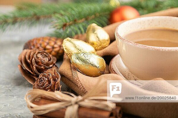 Weihnachten oder Neujahr Zusammensetzung. Dekorationen  Zapfen  Zimt  Tannen und Fichtenzweige  Tasse Kaffee  Wollschal auf einem grauen Betonhintergrund. Seitenansicht  Nahaufnahme  selektiver Fokus