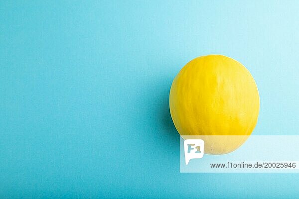 Reife gelbe Melone auf blauem pastellfarbenem Hintergrund. Draufsicht  flat lay  copy space. Ernte  gesund  vegane Ernährung  Konzept  Minimalismus