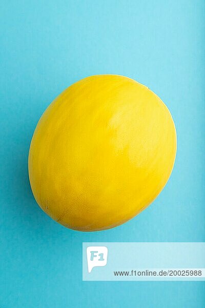 Reife gelbe Melone auf blauem pastellfarbenem Hintergrund. Draufsicht  Flat Lay  Nahaufnahme. Ernte  gesund  vegane Ernährung  Konzept  Minimalismus