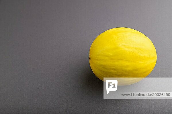 Reife gelbe Melone auf grauem pastellfarbenem Hintergrund. Seitenansicht  Kopie Raum. Ernte  gesund  vegane Lebensmittel  Konzept  Minimalismus