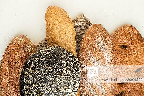 Verschiedene Arten von frisch gebackenem Brot auf einem weißen hölzernen Hintergrund. Ansicht von oben  flach legen  Nahaufnahme
