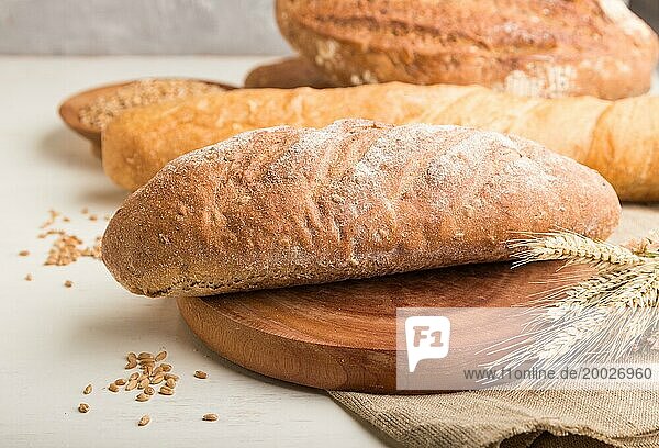 Verschiedene Arten von frisch gebackenem Brot auf einem weißen hölzernen Hintergrund. Seitenansicht  Nahaufnahme  selektiver Fokus