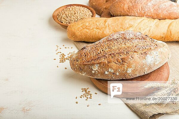 Verschiedene Arten von frisch gebackenem Brot auf einem weißen hölzernen Hintergrund. Seitenansicht  Nahaufnahme  Kopie Raum