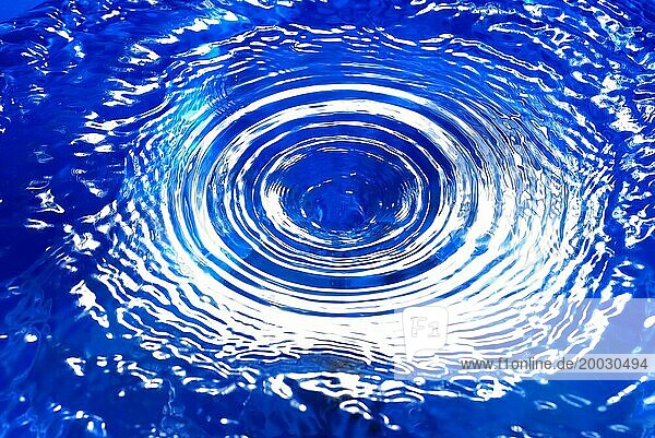 Ein Wasserwirbel in blauem Wasser  mit konzentrischen Kreisen
