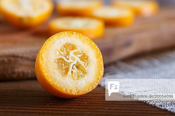 Sliced kumquats on a wooden kitchen board  close up  selective focus