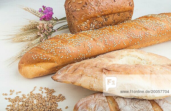 Verschiedene Arten von frisch gebackenem Brot auf einem weißen Holzhintergrund. Seitenansicht  Nahaufnahme