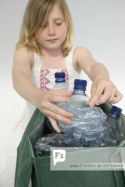 Young Girl Recycling Plastic Water Bottles
