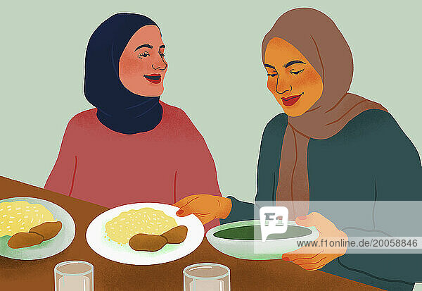 Happy women friends in hijabs enjoying dinner together at table