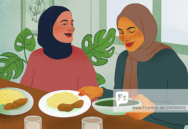 Women friends in hijabs eating together at table
