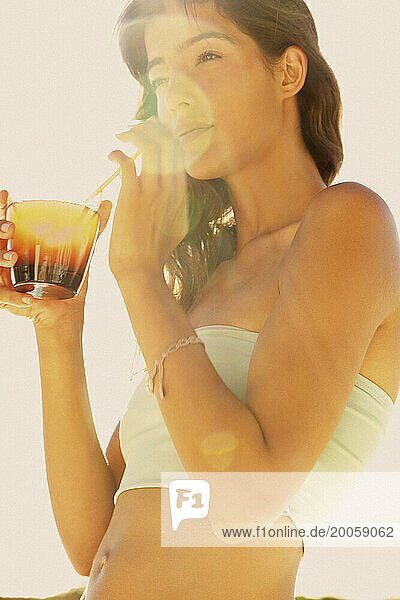 Young Woman Drinking Cocktail in Sunlight