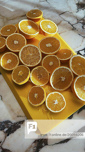 Fresh orange cross sections on cutting board on marble counter
