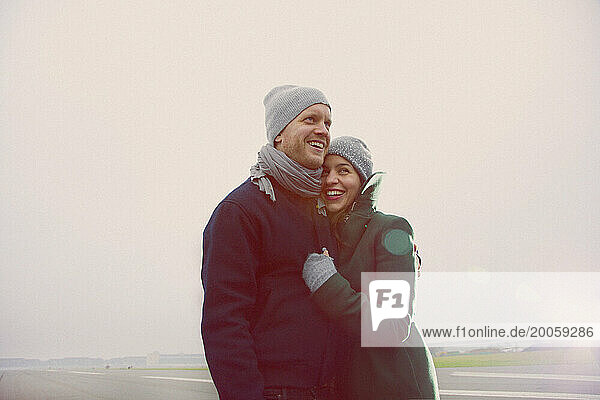 Smiling Couple Embracing on Airport Runway