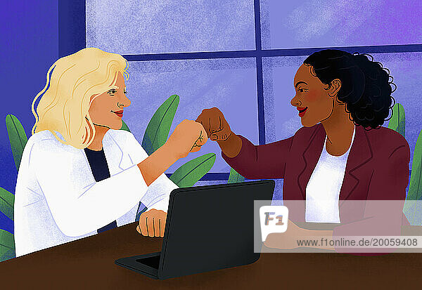 Happy  confident businesswomen fist bumping at laptop in conference room meeting