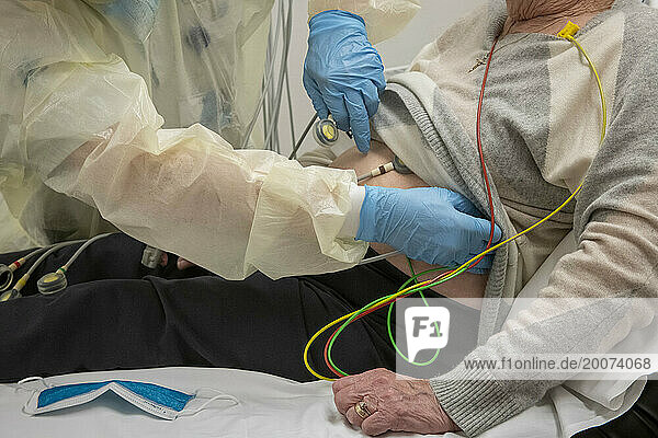 Elderly lady in a hospital bed under observation with healthy issues. Heart monitor and having her blood taken for tests