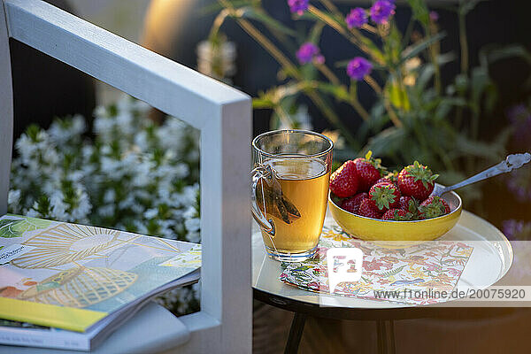 Beakfast of tea and strawberries on a beautiful table in the summer sunshine.