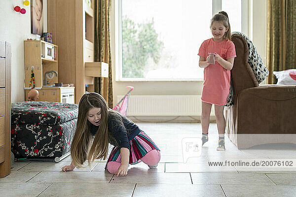 young sisters playing in their living room having fun bonding together