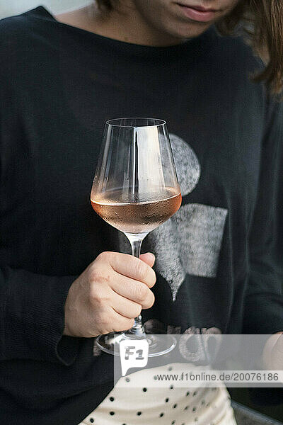 woman holding a glass of rose wine