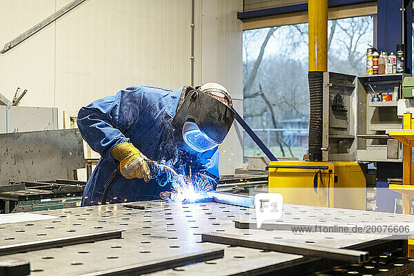 Man welding metal together for a client