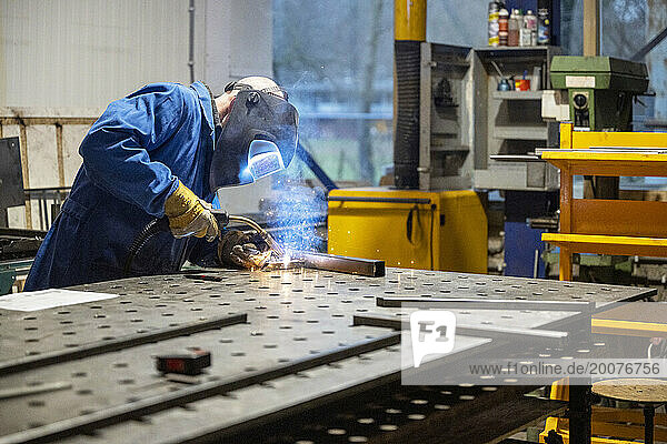 Man welding metal together for a client