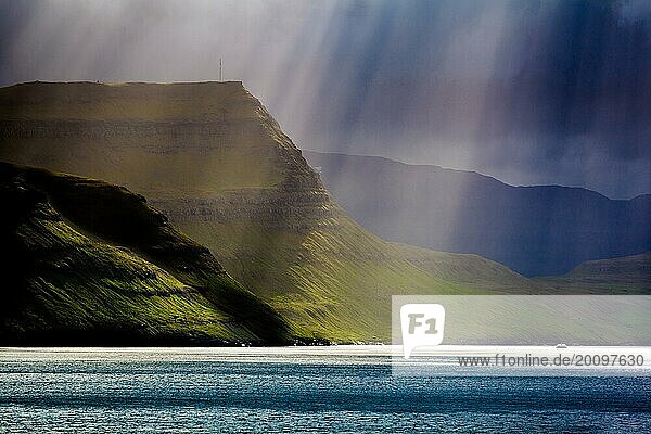 Sunbeam breaks through the clouds onto the coast of Faroe Islands