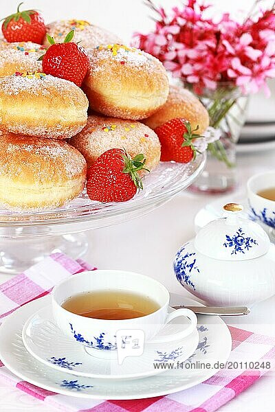Doughnuts filled with strawberry jam German national dish with a cup of tea