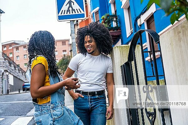 Afrikanische Freunde  die sich im Eingang eines Hauses mit blau gestrichener Fassade unterhalten