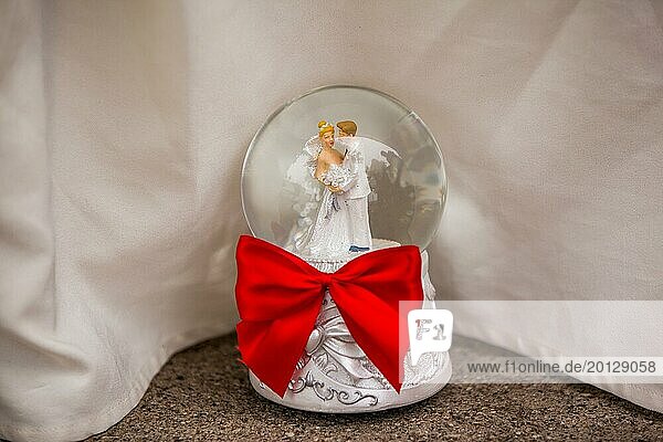 Snow globe with bridal couple and red ribbon