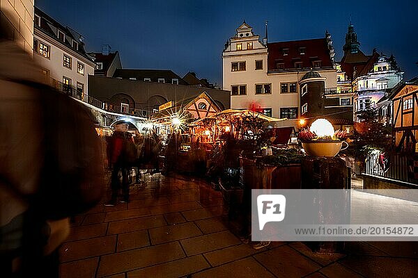Nächtliche Szene eines belebten Weihnachtsmarktes mit festlich beleuchteten Gebäuden und verschwommenen Passanten  Dresdner Weihnachtsmarkt