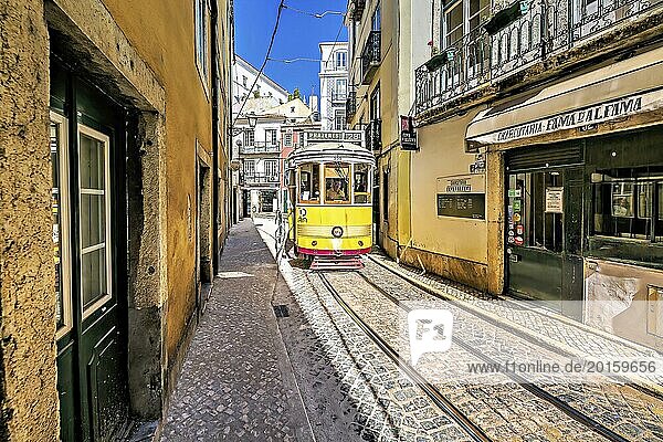 Eine alte gelbe Straßenbahn fährt durch eine enge Gasse mit Kopfsteinpflaster in Lissabon und spiegelt die sonnige  lebhafte Atmosphäre der Stadt wider  Alfama  Lissabon