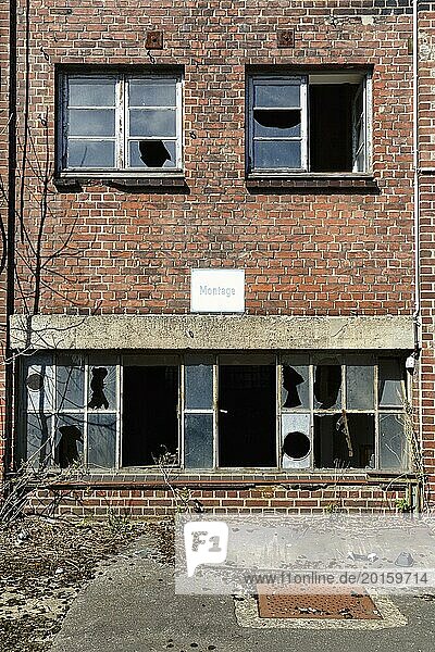 Leere verfallene Fabrikhalle  kaputte Fensterscheiben  Schild mit Aufschrift Montage  Industrieruine  Backstein  Fassadendetail  Lost Place  Deutschland  Europa