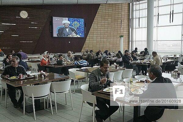 A mullah is seen on a large screen in a modern restaurant at a motorway service station  13.03.2019